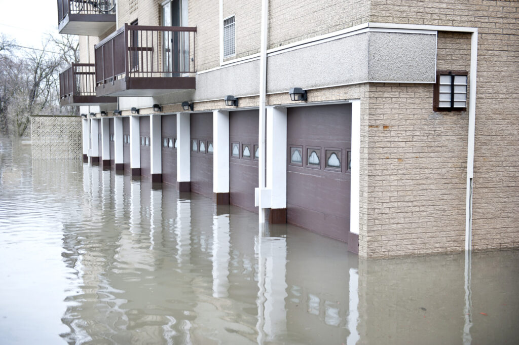 Floodwater covering the ground-floor garages of a multi-unit condominium building